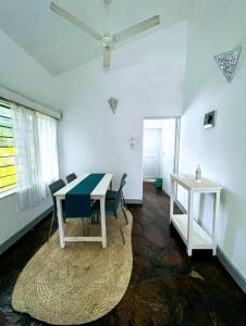 基利菲2 Bedroom Holiday Cottages Bofa Road, Kilifi的客房配有桌椅和吊扇。