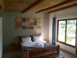 维兰库卢什Telvina Beach Lodge的一间卧室配有一张床,内设窗户