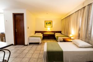 库里提巴Hotel Golden Star的酒店客房设有三张床和一张桌子