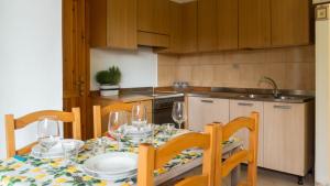 波尔托奥蒂罗卢Casa Ficus的厨房配有桌椅和酒杯