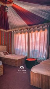 瓦迪拉姆RUM ALIENA LUXURY CAMP的一间卧室设有两张床和天篷