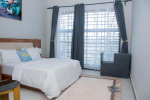 BabatiLadari Apartments的卧室设有白色的床和大窗户