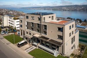 豪尔根aestate living lakeview in Horgen Zürich Zug Pfäffikon的一座白色的大建筑,前面有一辆汽车