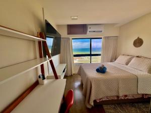 萨尔瓦多Ondina Apart Hotel Residences的一间卧室设有一张床和一个大窗户