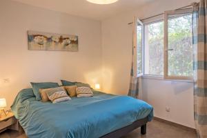 帕特里莫尼奥Casa U Castagnettu的一间卧室配有一张带蓝色床单的床和一扇窗户。