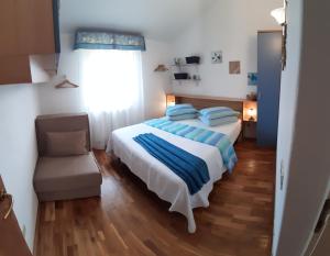 加利扎纳Apartments Demori的卧室配有床、椅子和窗户。