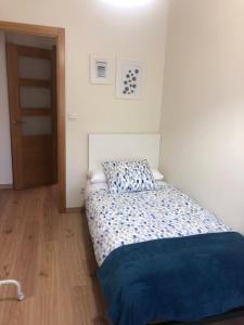 圣地亚哥－德孔波斯特拉Alojamiento ideal en Santiago的小卧室配有一张带蓝色毯子的床