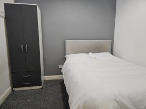 特伦特河畔斯托克Hygis Great Home of Relaxations的一间卧室配有一张床和一个黑色橱柜