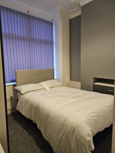 特伦特河畔斯托克Hygis Great Home of Relaxations的卧室配有一张大白色床和窗户