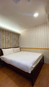 台北微笑逗点的一间卧室配有一张带白色床单的大床