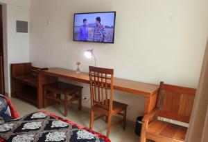 杜阿拉GRAND HOTEL CITY, Douala的一间设有一张桌子的房间,墙上配有电视
