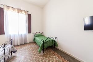特拉帕尼伐戴拉250公寓的一间卧室配有一张带绿毯的床