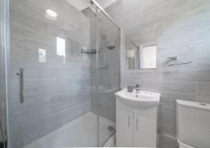 GoodmayesUksas 4 bed house Free parking的带淋浴、卫生间和盥洗盆的浴室