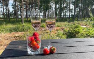 赛夫勒Beautiful Home In Sffle With Kitchen的桌子上放两杯葡萄酒和草莓