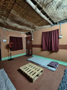 黎明之村Chords of Nature Hostels & Hut Stays Pondicherry的客房设有两张床和窗户。
