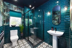 诺丁汉Fairview Boutique Apartments in West Bridgford Centre的蓝色瓷砖浴室设有卫生间和水槽