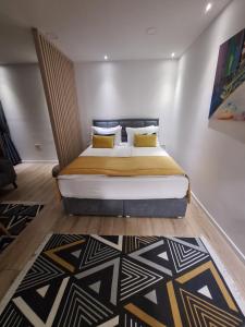 萨拉热窝Apartman Orhideja with Free Parking的一间卧室配有一张带黄色枕头的大床
