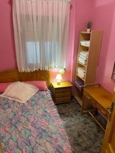 埃尔佩雷略Broadway es Mar的一间卧室配有一张床、一张书桌和一个窗户。