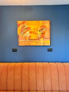 旧瓦马H by Hambar的一张沙发旁的蓝色墙上的画