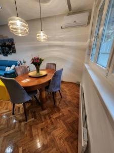 BežanijaNancy's Cozy Business Apartment的一间带木桌和椅子的用餐室