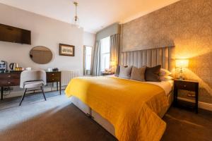 皇家滕布里奇韦尔斯皇家威尔斯酒店的一间卧室配有黄色的床和一张书桌