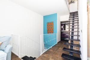 圣玛丽亚纳瓦雷Sa Dommu e Mare的客厅里有一个螺旋楼梯,有蓝色的墙壁