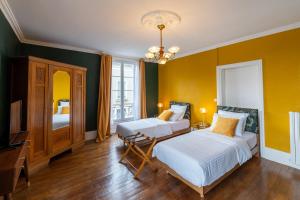 拉弗雷切Villa du Loir的一间卧室设有两张床,拥有黄色的墙壁