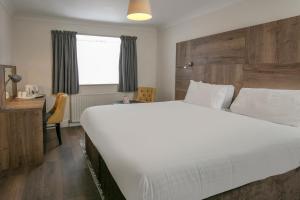 沃特福德贝斯特韦斯特白宫酒店的卧室配有一张白色大床和一张书桌