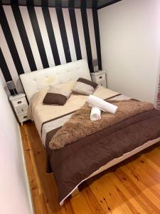 波尔图AL Pitões的一张带黑白条纹床头板的床