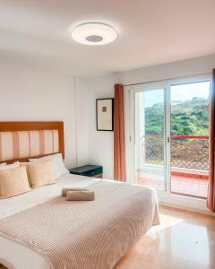 阿尔加德萨Albatross Golf Suite Alcaidesa的一间卧室设有一张床和一个大窗户