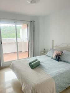 阿尔加德萨Albatross Golf Suite Alcaidesa的一间卧室设有一张大床和大窗户