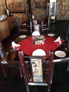 哈博罗内The Big Five Lodge的一张餐桌,上面有红桌布
