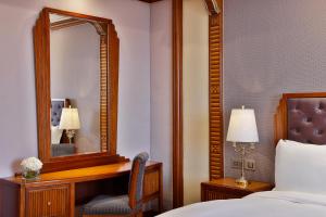 吉达吉达丽思卡尔顿酒店 的一间卧室配有镜子、一张床和一把椅子