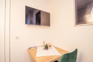 贝尔吉施格拉德巴赫Hotel Dona的一张桌子,墙上挂着电视