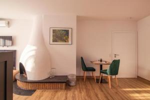 贝尔吉施格拉德巴赫Hotel Dona的客厅配有桌子和两把绿色椅子