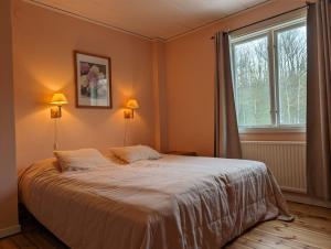 DegerhamnBrukshotellet Öland - kursgård och vandrarhem的一间卧室设有一张大床和一个窗户。