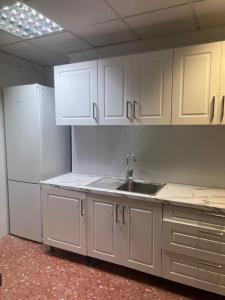 阿利坎特just hostel capsules的厨房配有白色橱柜和水槽