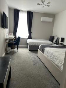 滨海克拉克顿The Royal Hotel - Clacton On Sea的酒店客房设有两张床和窗户。