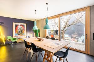 贡德尔芬根FRIZ Art的一间带桌椅和大窗户的用餐室