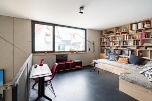 贡德尔芬根FRIZ Art的客厅配有沙发、桌子和书桌