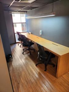 巴鲁埃里AlphaStay - Adágio的一个带木桌和椅子的办公室隔间