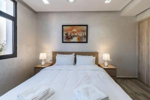 卡萨布兰卡Chic Apartment Cosy Stay的一间卧室配有一张带两盏灯的大型白色床。