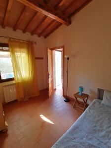 Sant'ErmoAgriturismo Campolungo的一间卧室配有一张床、一张桌子和一个窗户。