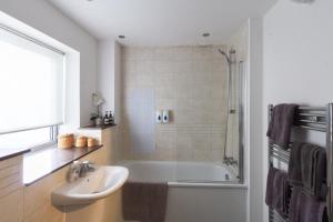 伦敦宽敞中央家庭公寓的带浴缸、水槽和淋浴的浴室