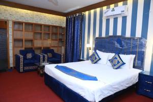 拉合尔Hotel palm east lahore的一间卧室配有一张蓝色和白色条纹的床
