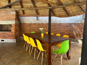 布隆方丹SiBella guest house的一间带木桌和黄色椅子的用餐室
