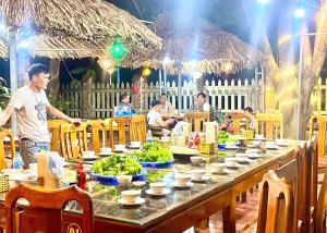 宁平Ninh Binh Mountain View Homestay & Restaurant的站在长桌前吃着食物的人