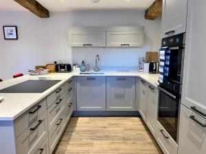 科尔福德Stunning 3-Bed Cottage in The Forest of Dean的铺有木地板的厨房配有白色家电