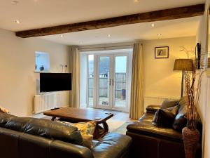 科尔福德Stunning 3-Bed Cottage in The Forest of Dean的客厅配有真皮沙发和桌子
