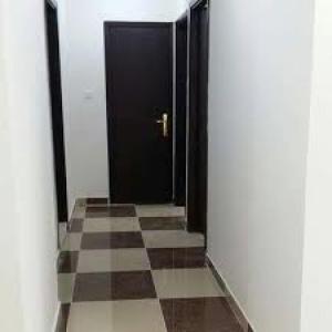 伊尔比德GMR House的走廊上设有黑色的门和 ⁇ 格地板